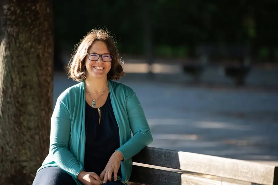 marie_meyer_marktl_business_coach Marie Meyer-Marktl sitzt auf eine Parkbank.