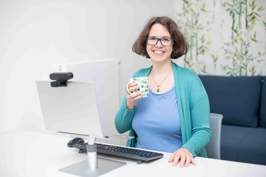 Berufliche Neuorientierung: Marie Meyer-Marktl am Computer mit einer Tasse in der Hand.